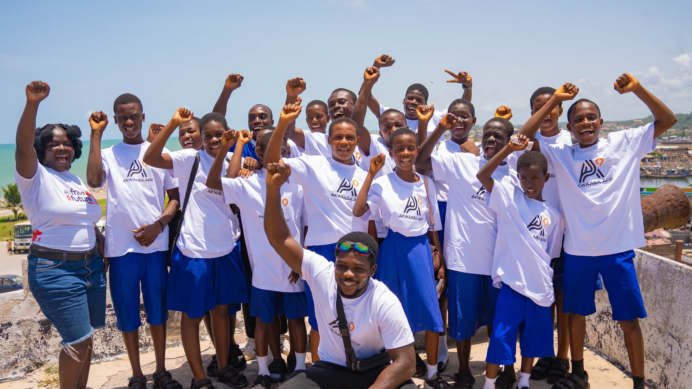 Akwaaba Foundation — Ghanaian schoolchildren at Cape Coast Castle, fists raised