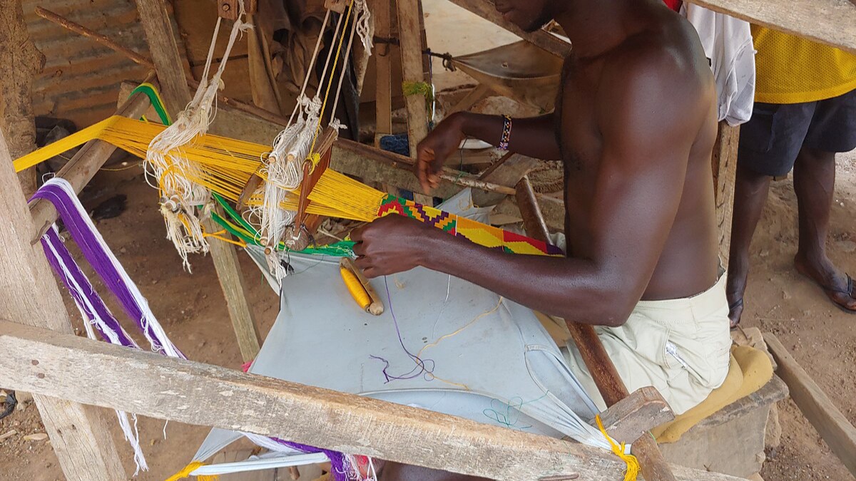 Master kente weaver at his loom in Bonwire, Ashanti Region — birthplace of Ghana's iconic handwoven kente cloth tradition