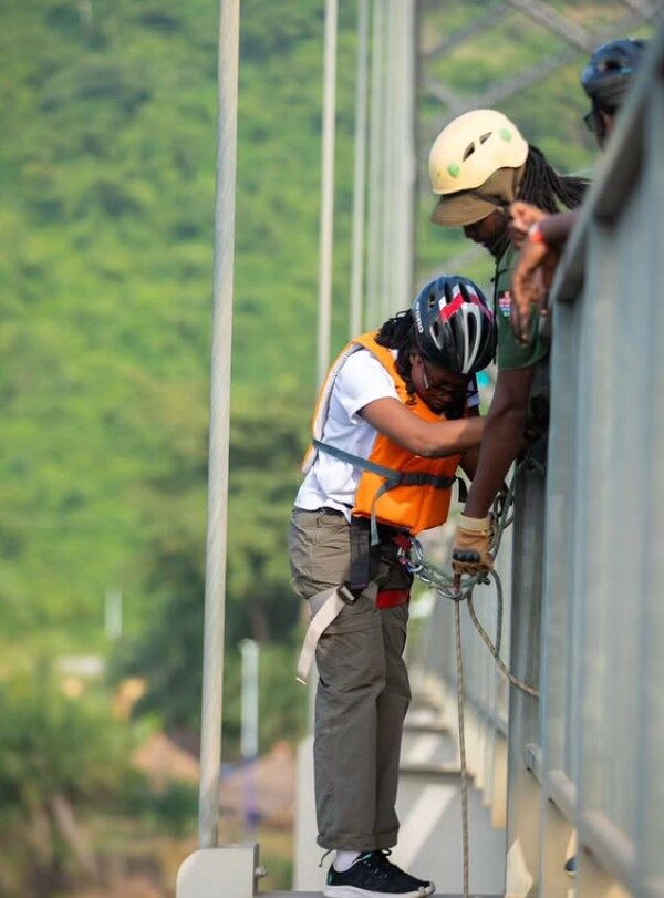 A guest going over the edge to start an abseil at Adomi Bridge