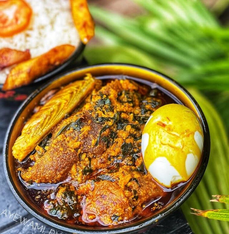 A plate of banku with grilled tilapia and green soup on an Accra food tour