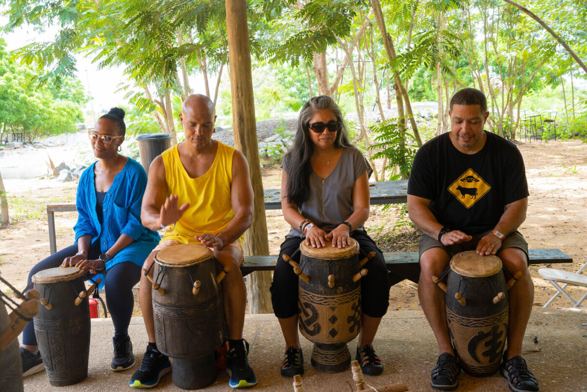 A group of visitors learning to play djembe drums together in Ghana