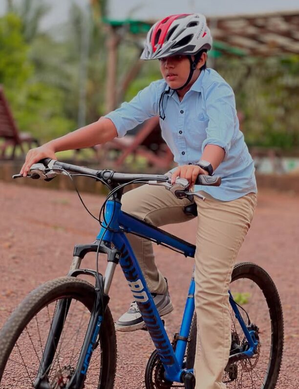 A guest mountain biking along a red-earth trail at a farm near Accra
