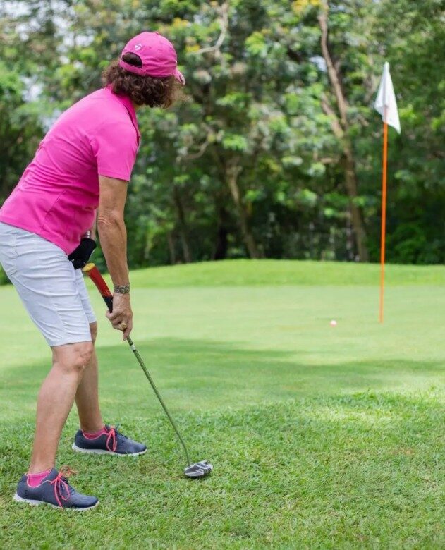 A golfer putting toward the flag on a green in Accra