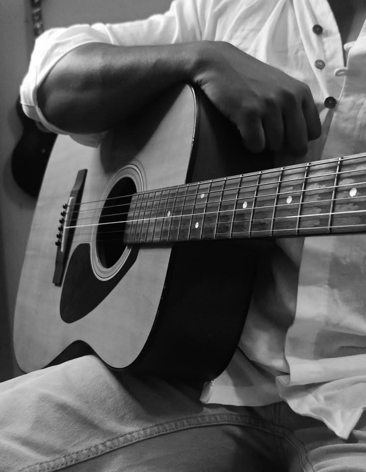 Hands playing an acoustic guitar during a lesson in Accra