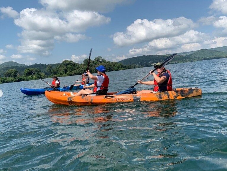 Kayaks on the open water of the Volta Lake with hills behind