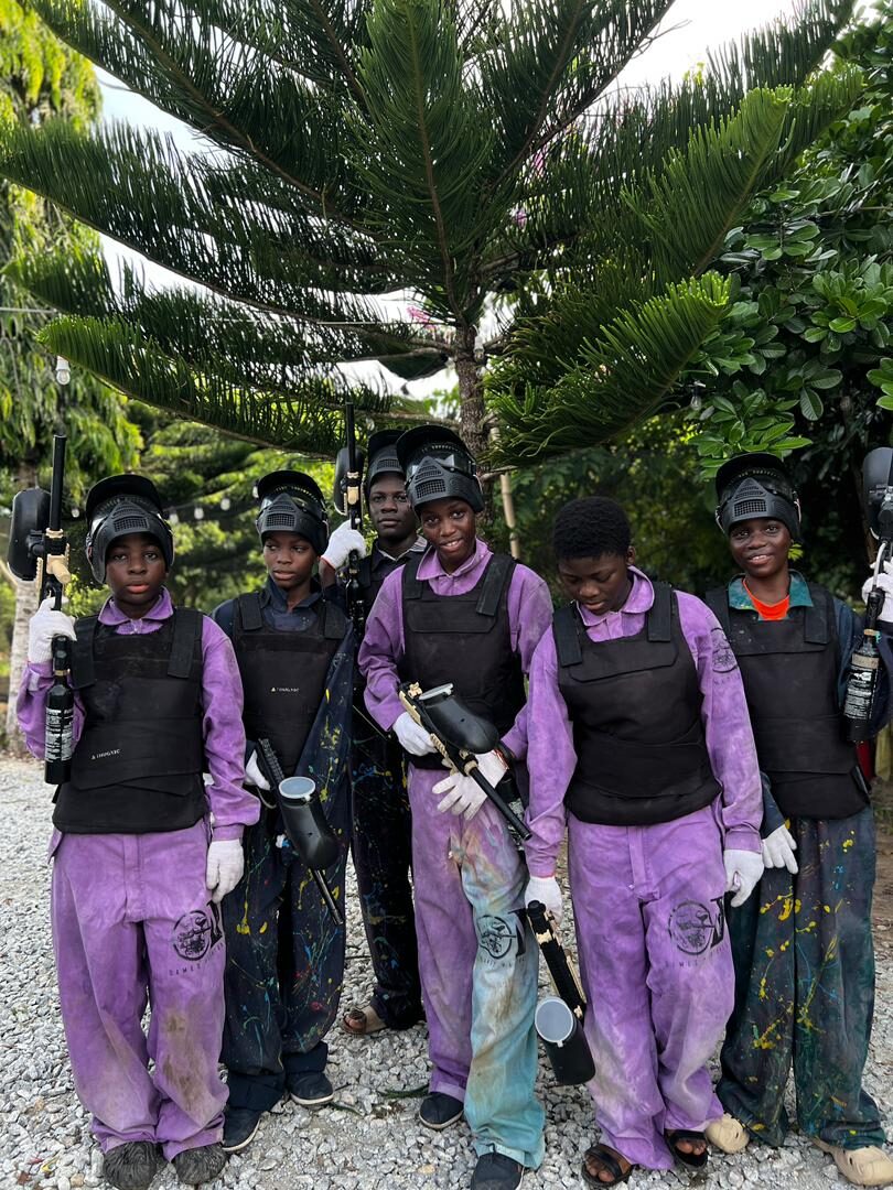 A team of guests in paintball gear and masks near Accra