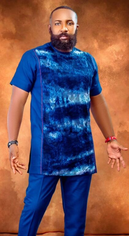 A man wearing a custom blue tie-dye African outfit styled in Accra