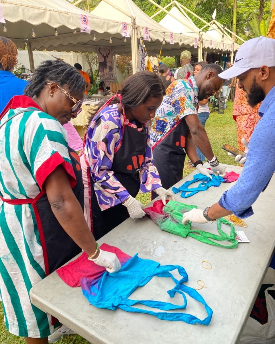 Group tie-dyeing fabric together at an outdoor tie and dye workshop in Accra, Ghana