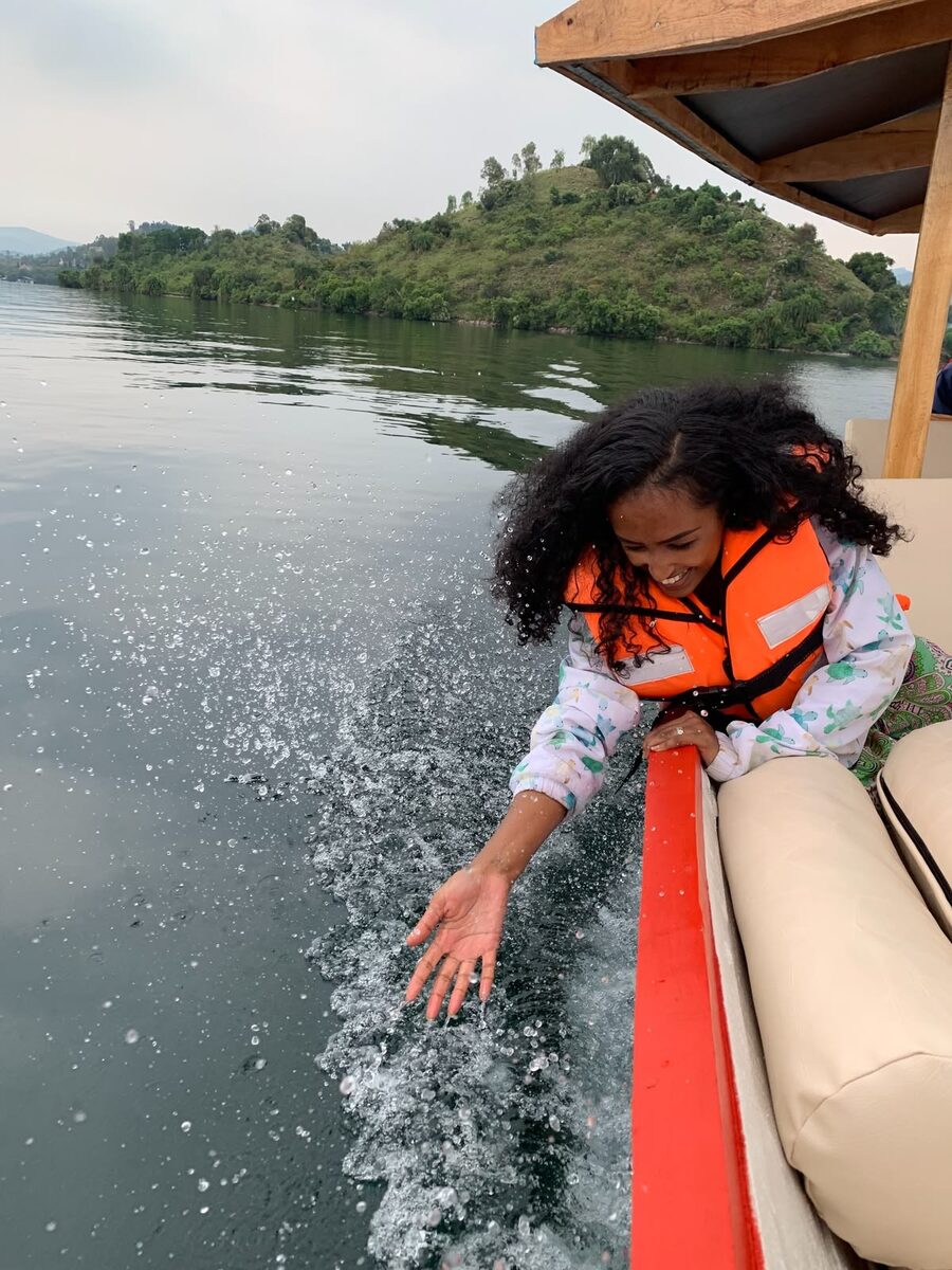 A guest trailing a hand in the water on a Volta Lake cruise