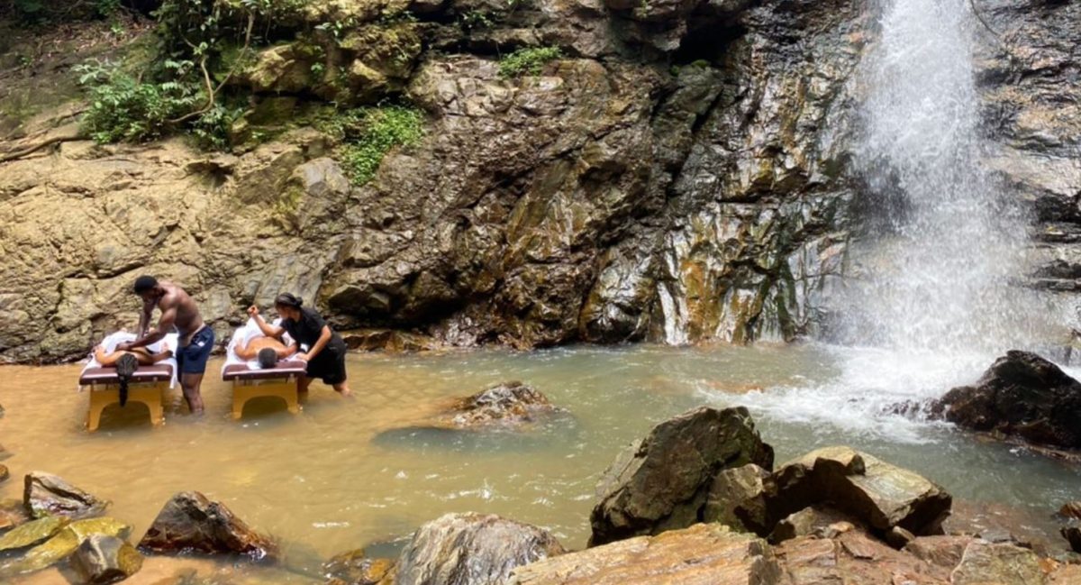 Guests receiving massages beside a waterfall pool in Ghana